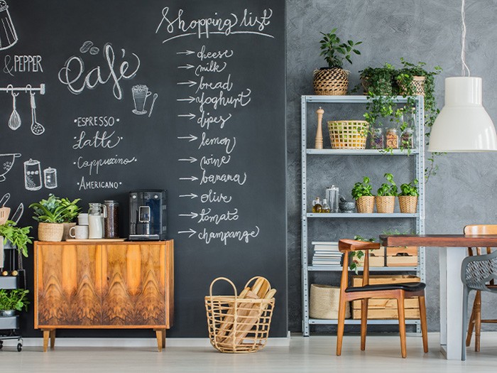 Kitchen featuring a black chalkboard wall with creative designs and a shopping list.